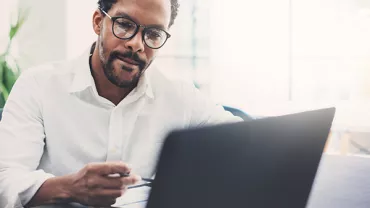 Person working on a laptop at a desk.