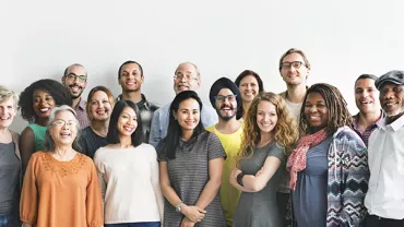 Group of people smiling, standing together.