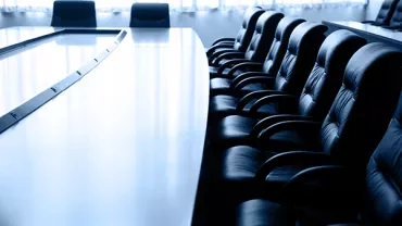 Long conference table with leather chairs arranged neatly.
