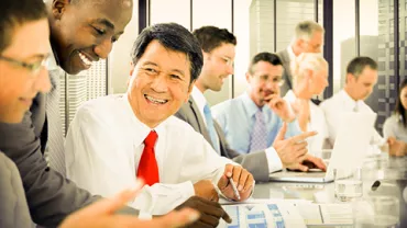 People in business attire having a meeting in a modern office.