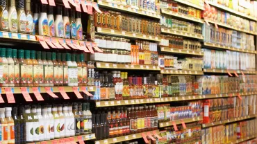 A grocery store aisle filled with salad dressings and condiments.
