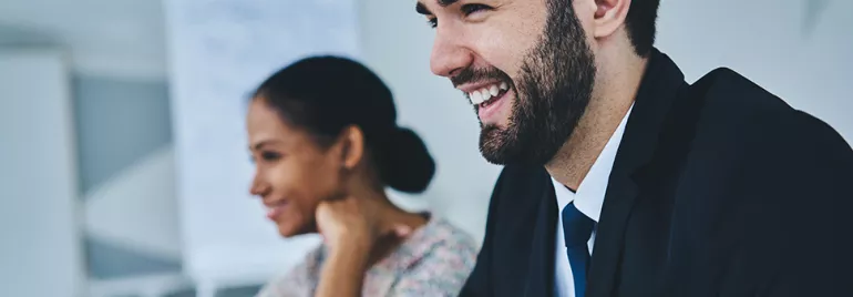 Two people smiling during a business meeting.
