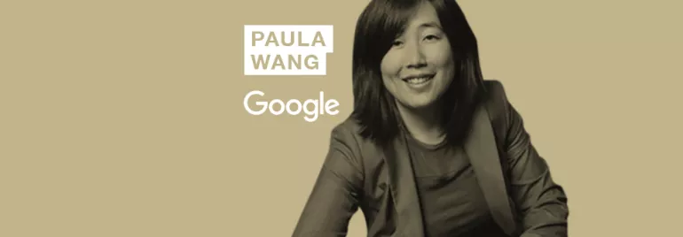 Person smiling in front of a beige background with Google logo.