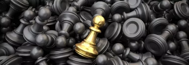 A golden pawn among many black chess pawns, symbolizing uniqueness.