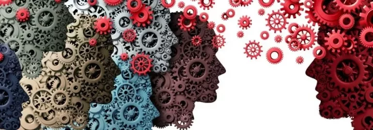 Silhouetted faces made of interconnected gears, symbolizing teamwork and communication.