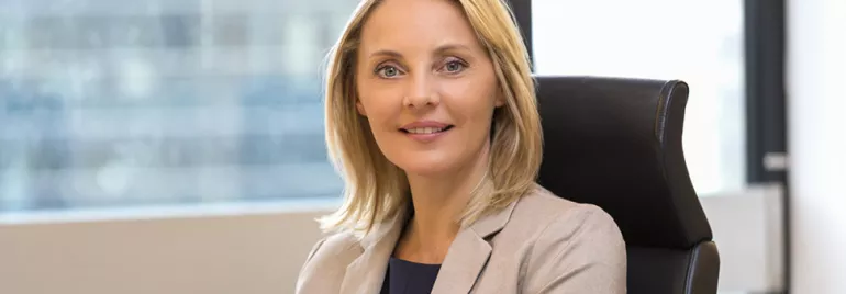 Person smiling while sitting in an office chair.