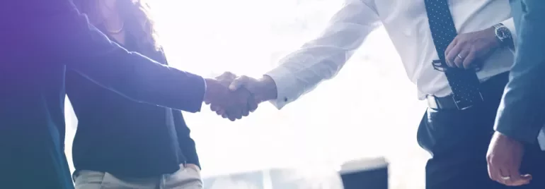 People shaking hands in a business setting.
