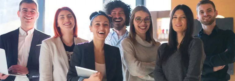 Group of smiling colleagues in an office setting.
