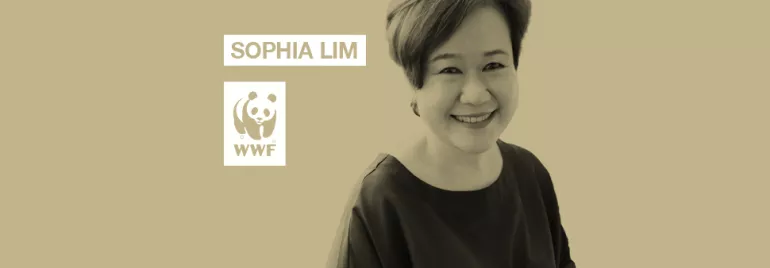 Person smiling in front of a beige background with WWF logo.