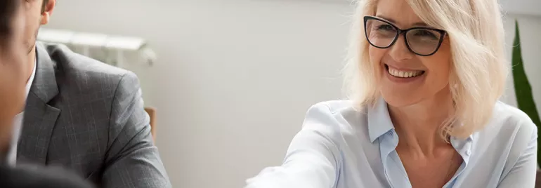 Person smiling and reaching out during a meeting.