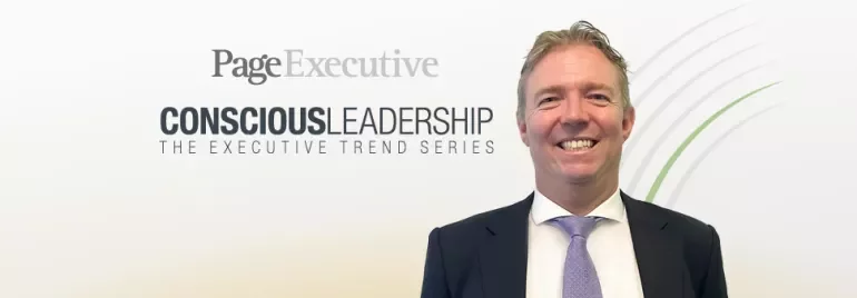 Person smiling in formal attire with 'Conscious Leadership' text in background.