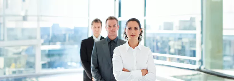 Business professionals standing in a modern office setting.