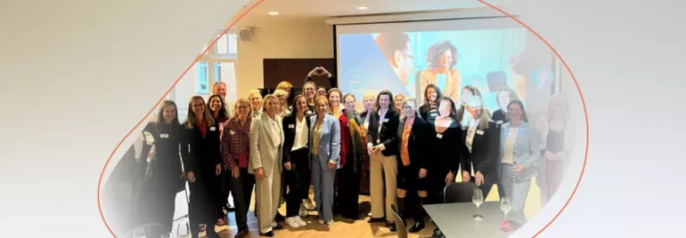 a group standing and smiling in a conference room