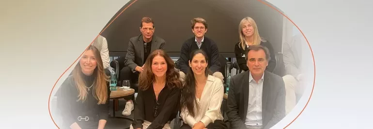 Group of people sitting and standing together in a meeting room.