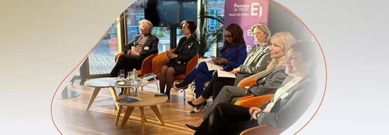 Panel discussion with professionals seated on stage during a corporate event.
