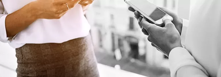 Two people using smartphones indoors