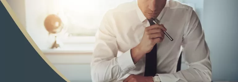 Person in formal attire reviewing documents at a desk.