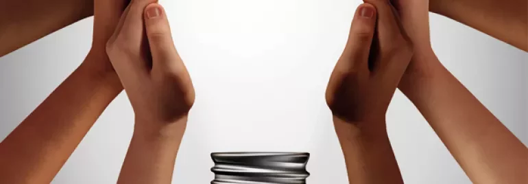 Diverse hands surround a coiled bulb base, symbolizing teamwork and innovation.