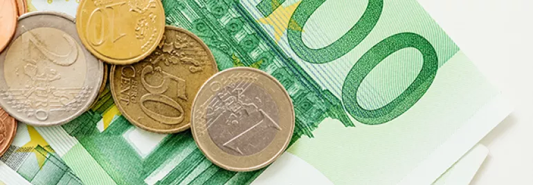 Euro coins and banknotes on a surface.