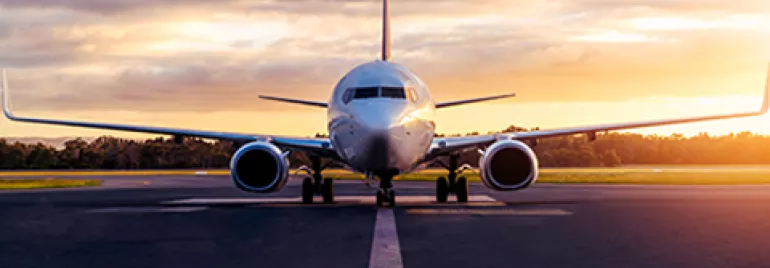 Airplane on runway during sunset, facing forward.