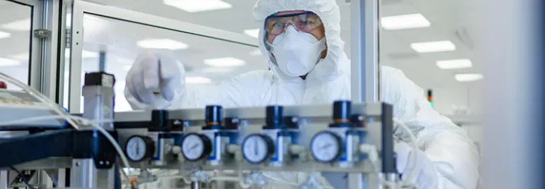 Person in protective suit working in a laboratory.
