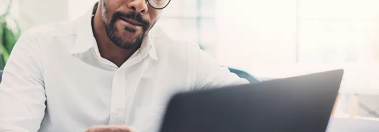 Person working on a laptop at a desk.