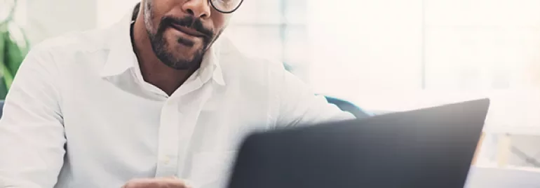 Person working on a laptop at a desk.