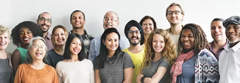 Group of people smiling, standing together.