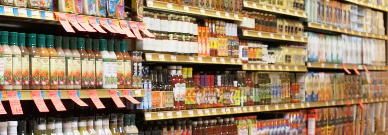 A grocery store aisle filled with salad dressings and condiments.