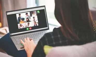 Person participating in a group video call on a laptop.