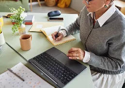 person working on a table with laptop