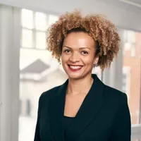Person smiling in a professional setting with a window in the background.