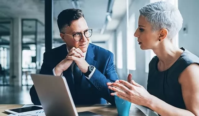 Two people having a discussion in an office setting.