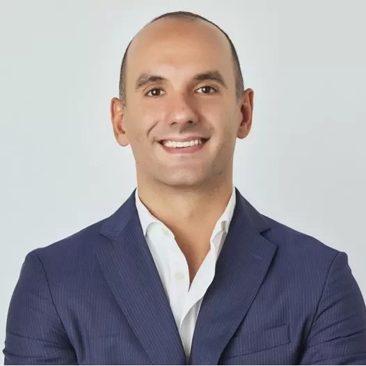 Person smiling in a blue suit with a white shirt.