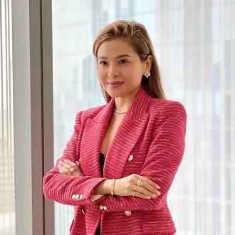 Person in red blazer standing confidently by a window.