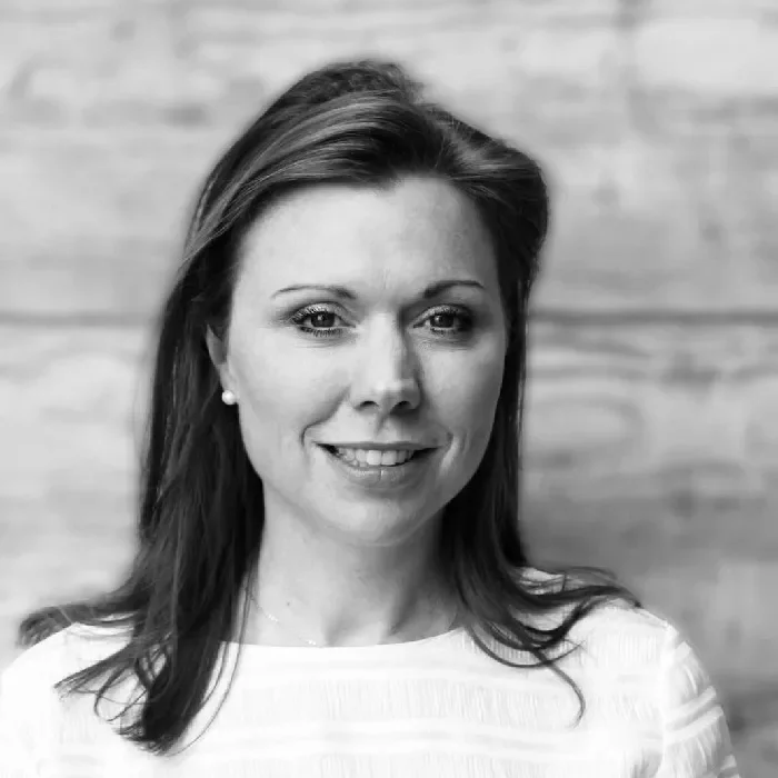 Black and white portrait of a person smiling softly.