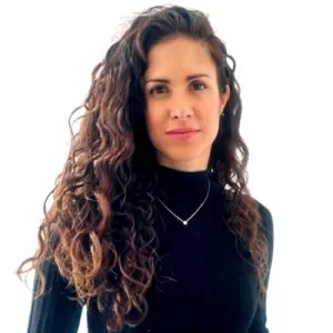 Person with long curly hair wearing a black turtleneck.