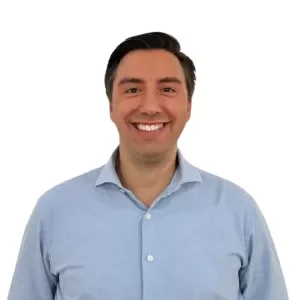 Person smiling in light blue shirt against white background.