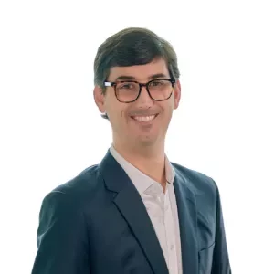Person in a suit smiling against a white background.