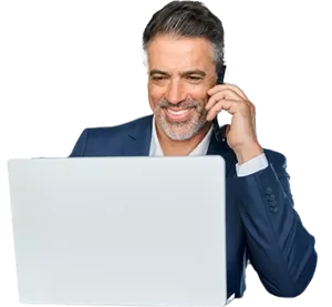 a man talking in his phone in front of his computer