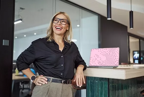 Person standing beside a counter in a modern office, with a laptop on the countertop.