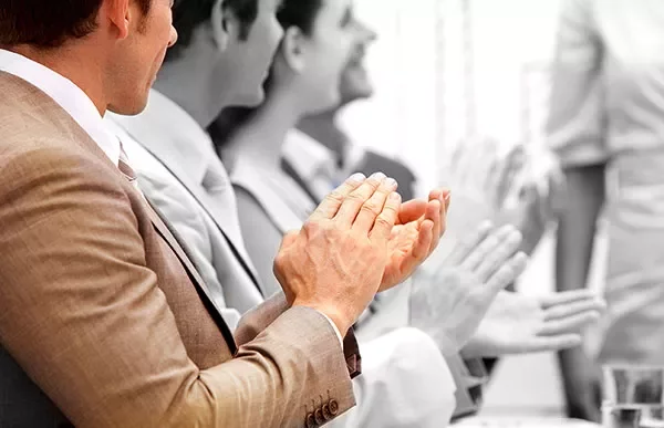 People sitting at a table, applauding.