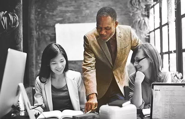 Three colleagues discussing a project around a table.