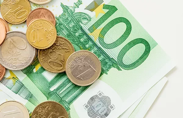 Euro coins and banknotes on a surface.