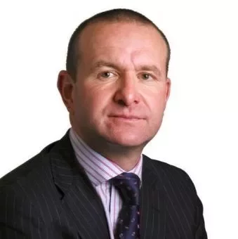 Person in a suit and tie against a white background.