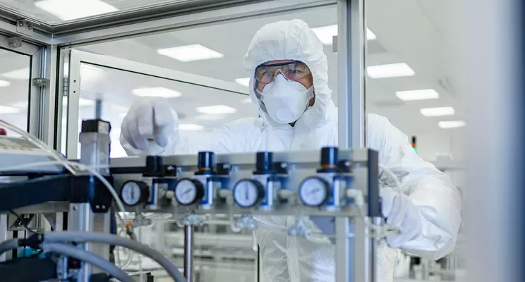 Person in protective suit working in a laboratory.