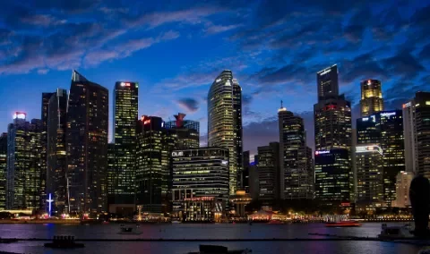Illuminated city skyline at dusk with skyscrapers by the water