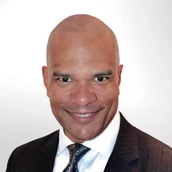 Person in a suit smiling at the camera.