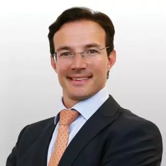 Portrait of a person in a suit with a light background.