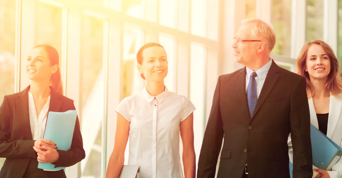 A group of professionals walking in an office corridor.